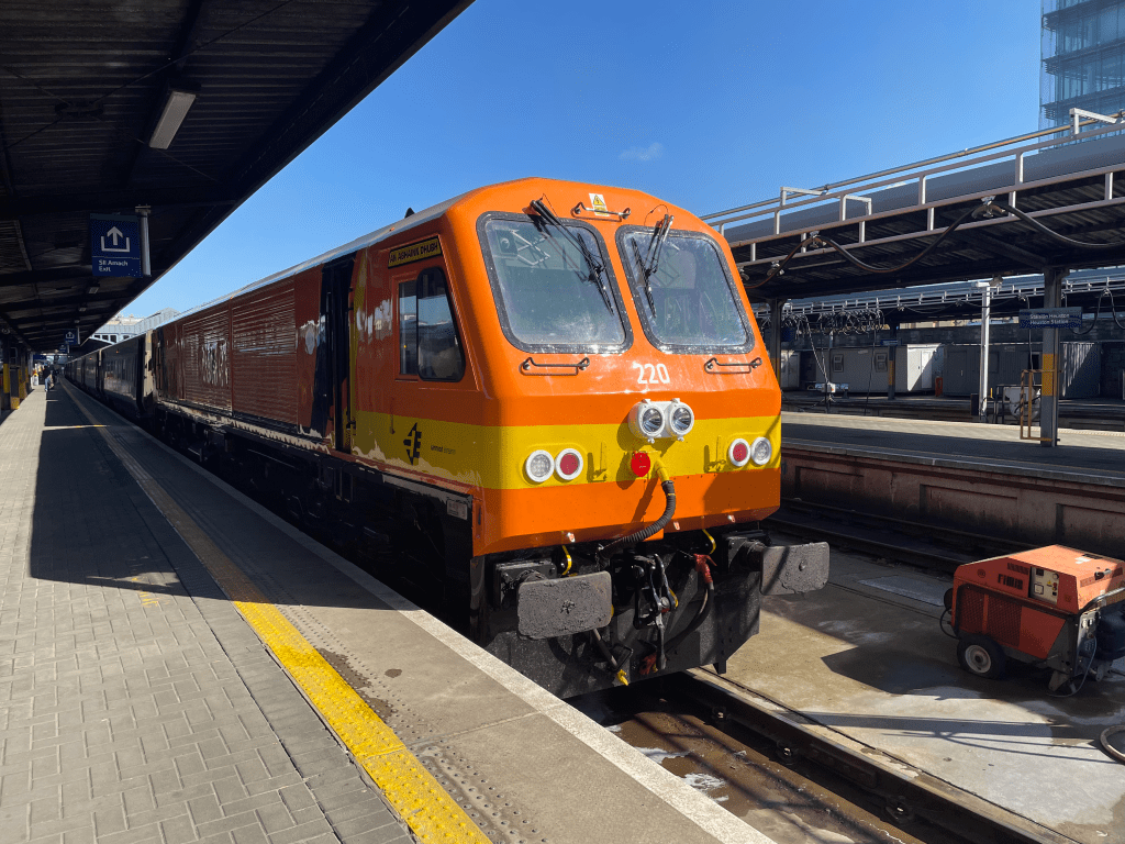 An orange railway locomotive in a platform